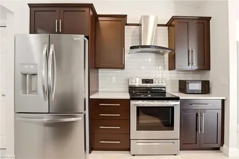 a kitchen with stainless steel appliances white cabinets and a refrigerator