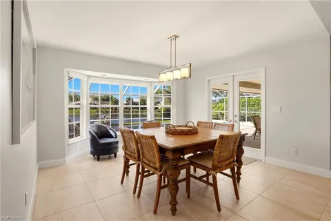 a view of a dining room and livingroom with furniture wooden floor and a chandelier