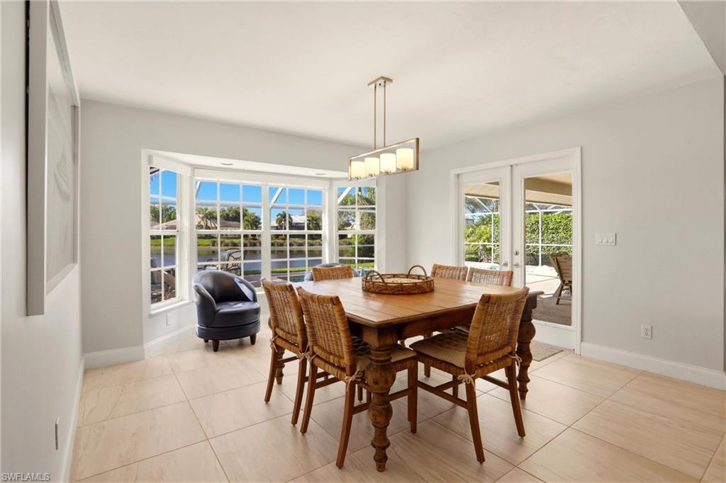 4282 Longshore Way North Naples, FL 34119 - Photo 13 of 43 Dining room featuring french doors and light tile patterned floors