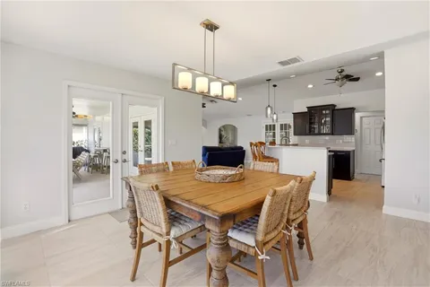 a view of a dining room and a kitchen with a table chairs