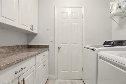 a utility room with cabinets washer and dryer