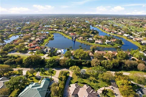 an aerial view of a city with lots of residential buildings and ocean view in back