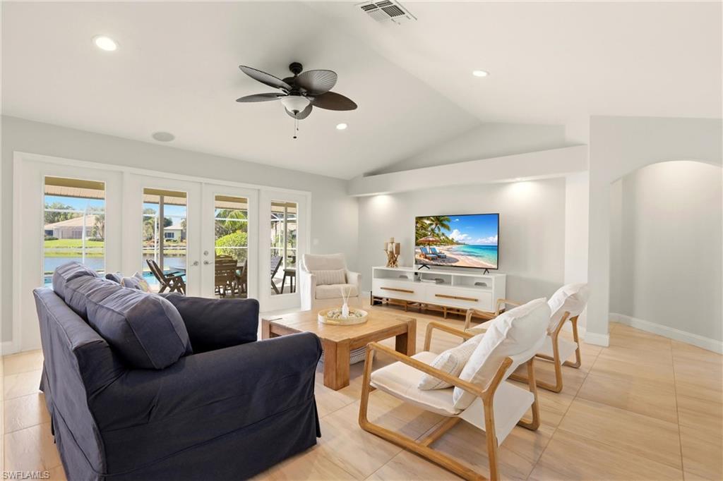 4282 Longshore Way North Naples, FL 34119 - Photo 6 of 43 Living room featuring ceiling fan, french doors, lofted ceiling, recessed lighting, and arched walkways