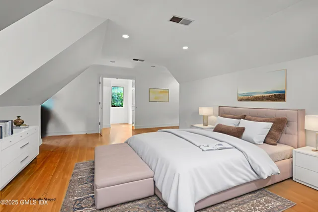 a bedroom with a bed and wooden floor