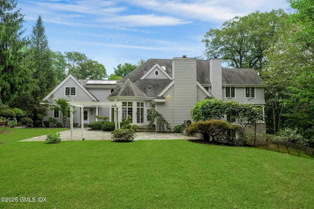 a front view of a house with a garden and trees