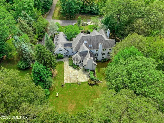 an aerial view of a house with swimming pool and garden