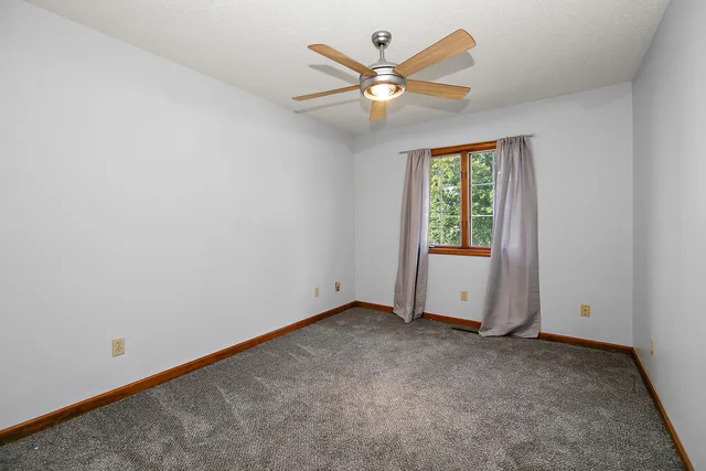 a view of an empty room with closet and a window