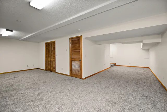 a view of an empty room with closet and a window