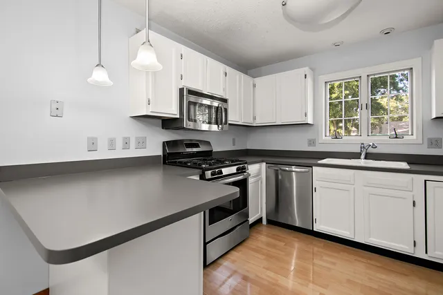 a kitchen with stainless steel appliances a sink a stove a microwave and cabinets