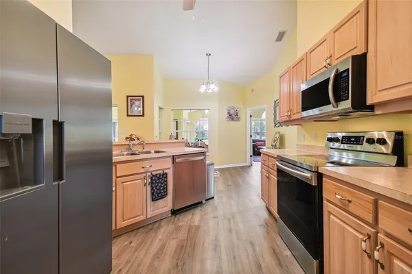a kitchen with stainless steel appliances granite countertop a stove a sink and a refrigerator
