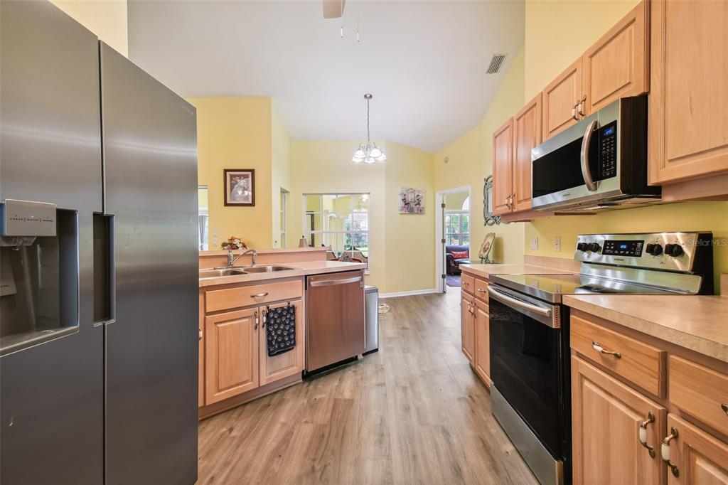 12728 Flamingo Parkway Spring Hill, FL 34610 - Photo 14 of 54 a kitchen with stainless steel appliances granite countertop a stove a sink and a refrigerator