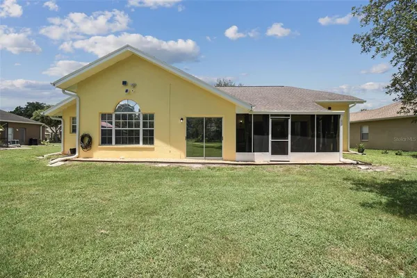 a view of a house with a yard and sitting area