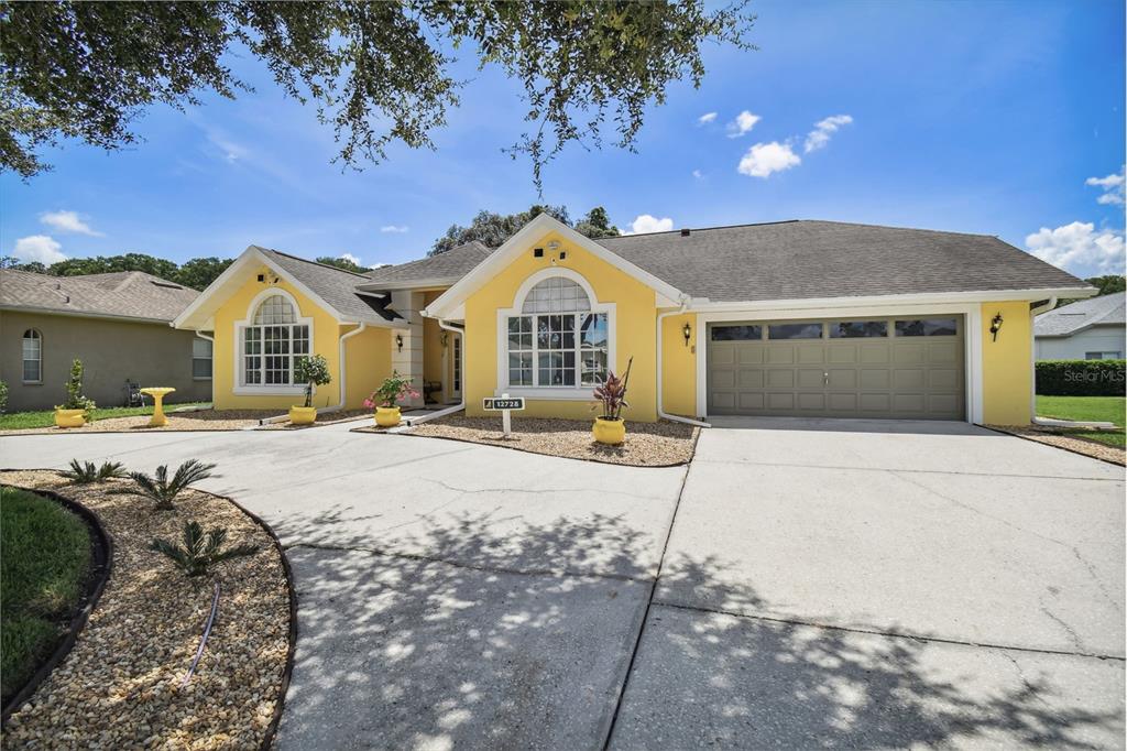 12728 Flamingo Parkway Spring Hill, FL 34610 - Photo 3 of 54 a front view of a house with a yard
