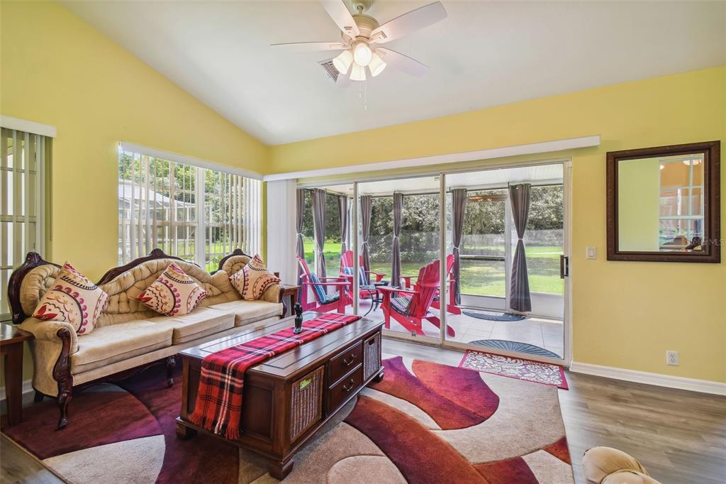 12728 Flamingo Parkway Spring Hill, FL 34610 - Photo 38 of 54 a living room with furniture and a floor to ceiling window