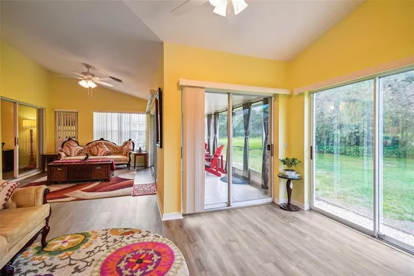 a living room with furniture a rug and a floor to ceiling window