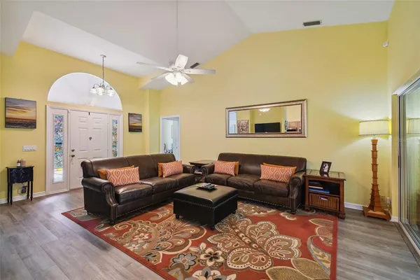 a living room with couches and a chandelier