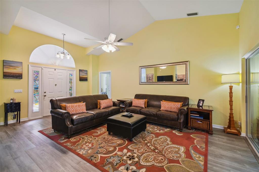 12728 Flamingo Parkway Spring Hill, FL 34610 - Photo 6 of 54 a living room with couches and a chandelier
