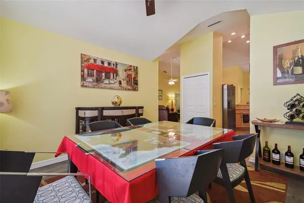 a living room with stainless steel appliances kitchen island granite countertop a dining table and chairs with wooden floor