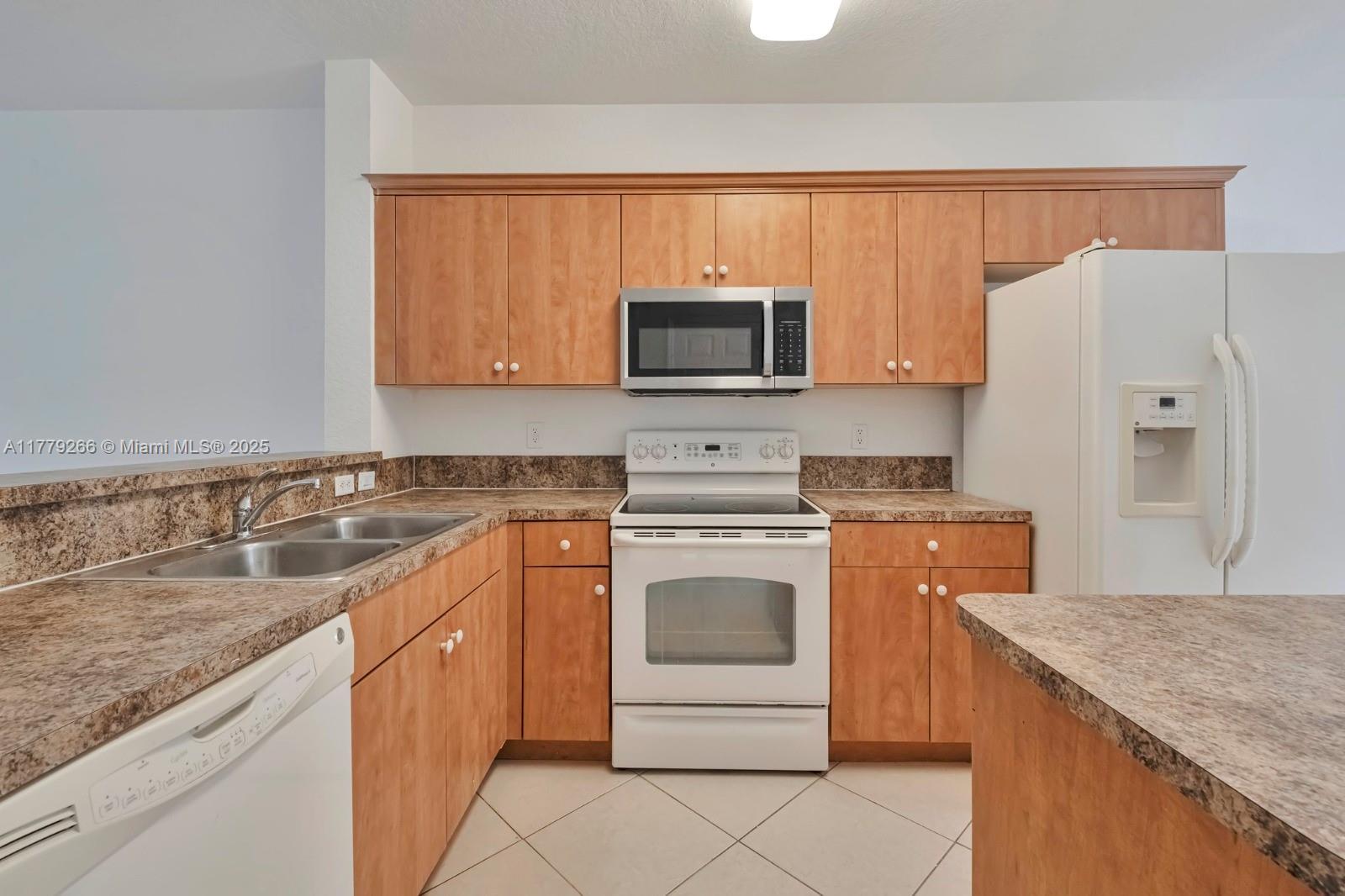 1925 Gardenia Court, Unit 1925 Riviera Beach, FL 33404 - Photo 3 of 10 a kitchen with a sink stove and microwave