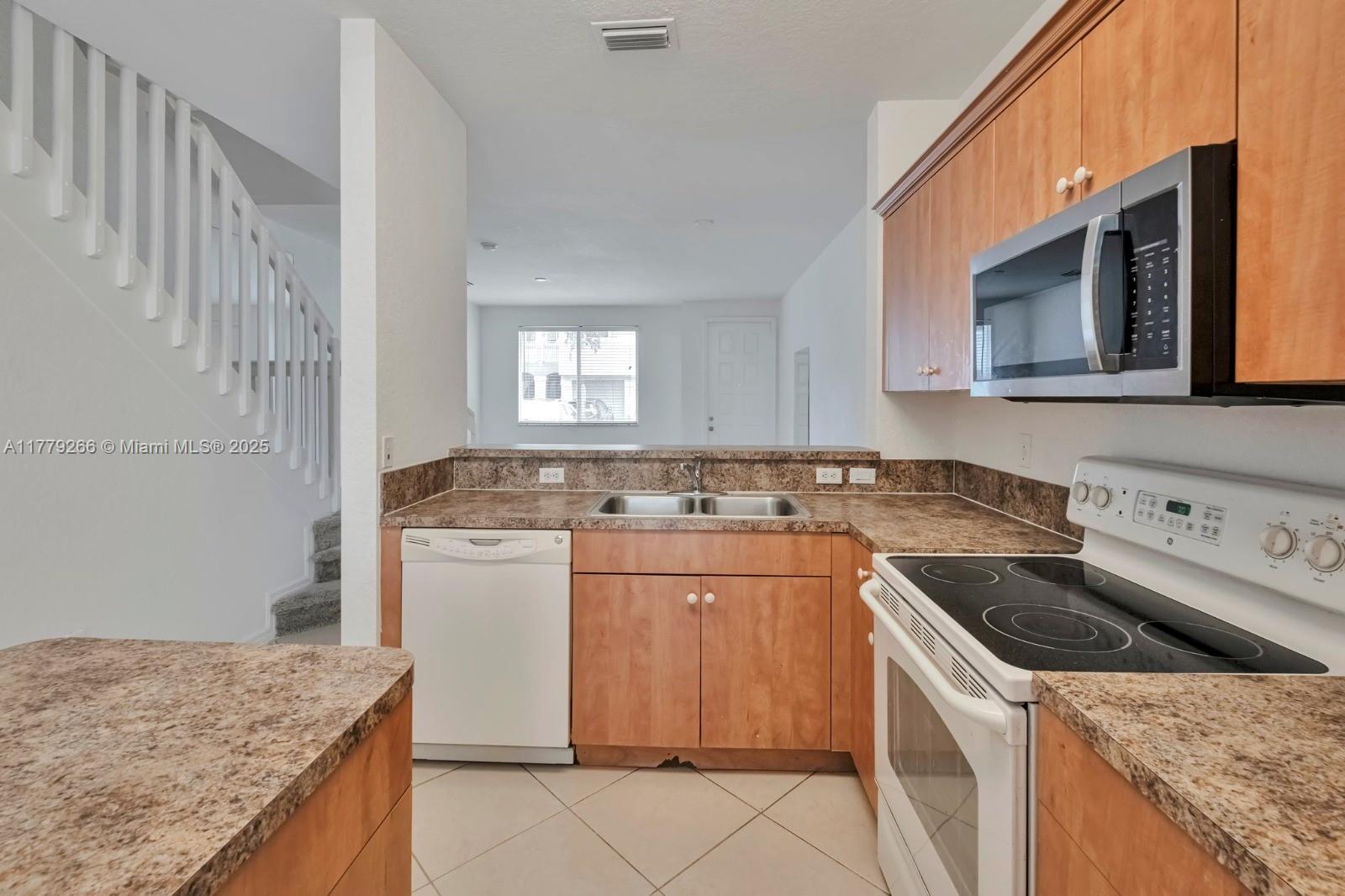 1925 Gardenia Court, Unit 1925 Riviera Beach, FL 33404 - Photo 5 of 10 a kitchen that has a sink and a stove