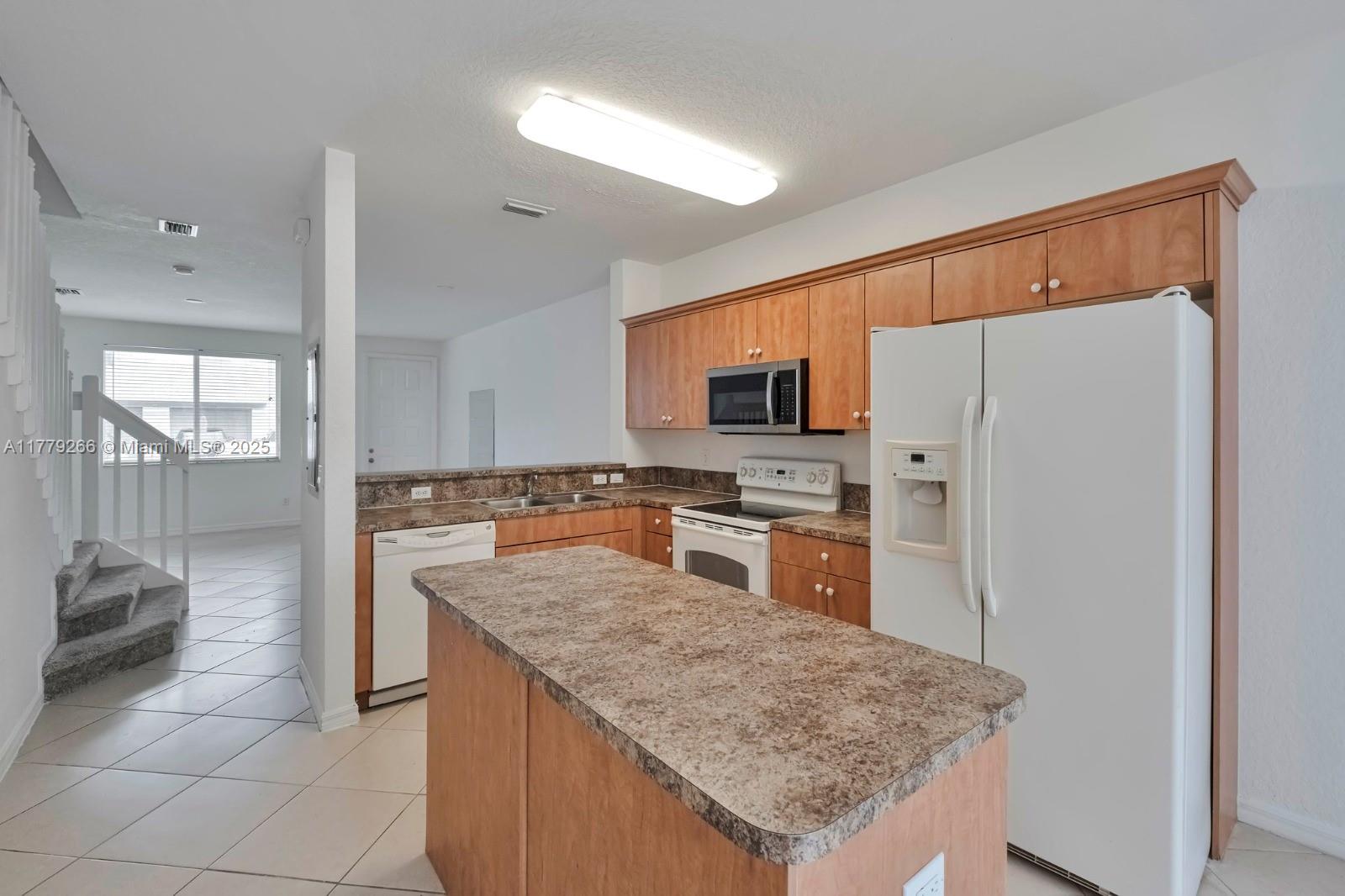 1925 Gardenia Court, Unit 1925 Riviera Beach, FL 33404 - Photo 6 of 10 a kitchen with stainless steel appliances granite countertop a sink counter space and refrigerator