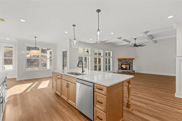 a view of a kitchen with kitchen island a sink wooden floor and a large window