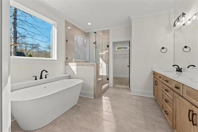 a spacious bathroom with a tub sink and mirror