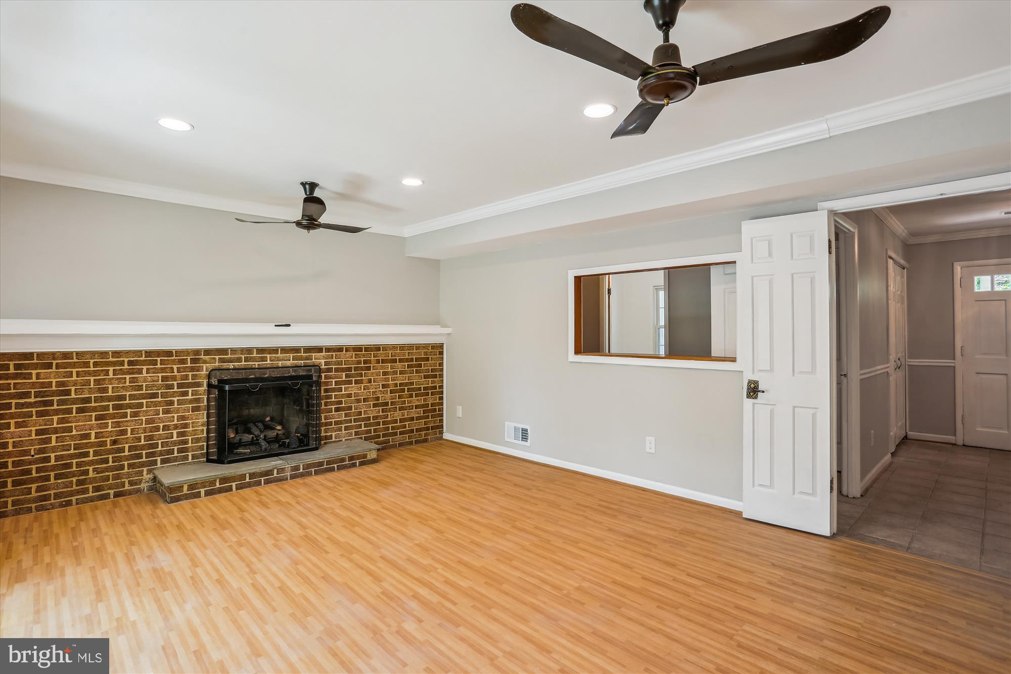 19916 Westerly Avenue Poolesville, MD 20837 - Photo 12 of 34 a view of an empty room with wooden floor fireplace and a window