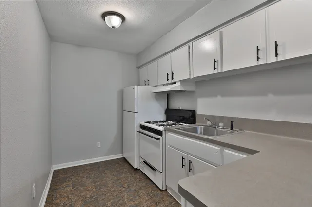 a kitchen with cabinets appliances and a sink