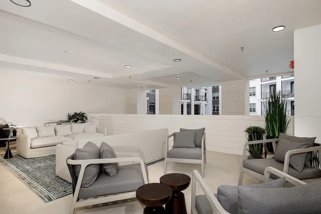 a living room with furniture and a table with bookshelf