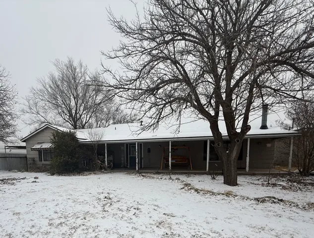 a front view of a house with a yard covered in snow