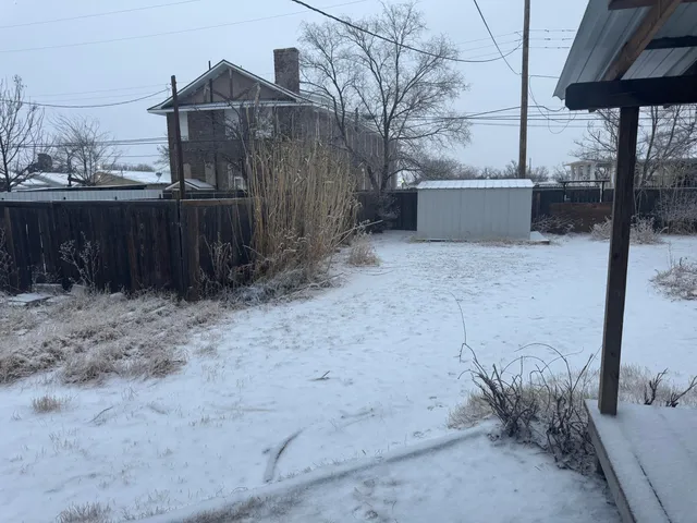 a kitchen with stainless steel appliances kitchen island granite countertop a refrigerator a stove and a sink with wooden floor