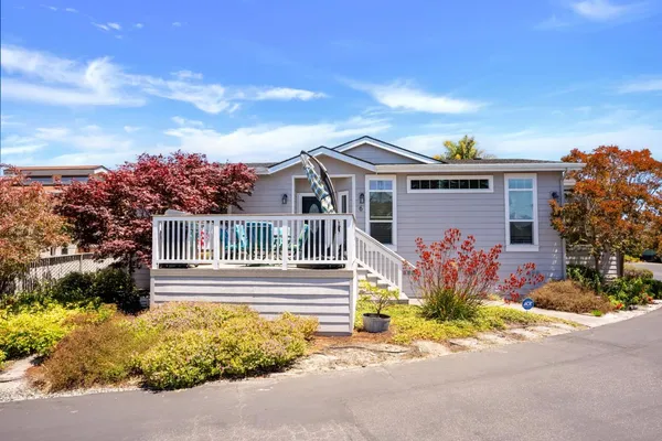 a front view of a house with a yard and potted plants