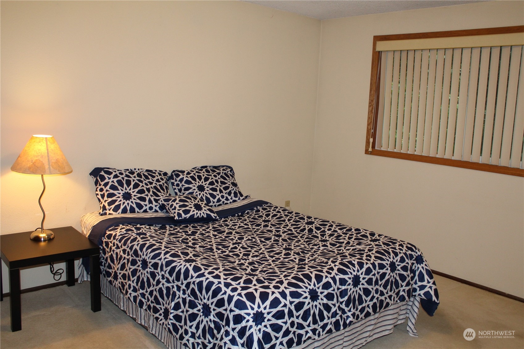 2519 Northeast 145th Street Seattle, WA 98125 - Photo 15 of 34 a bed sitting in a bedroom next to a window