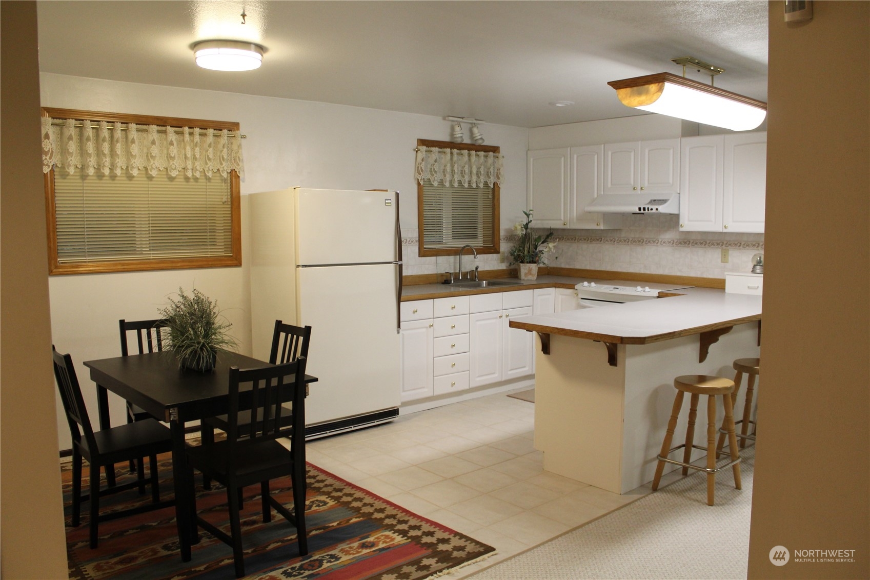 2519 Northeast 145th Street Seattle, WA 98125 - Photo 20 of 34 a kitchen with a table chairs and a refrigerator