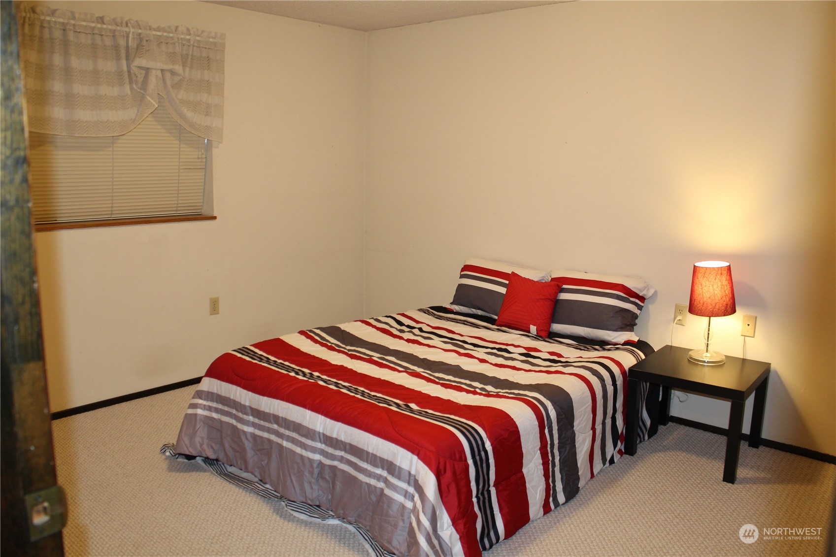 2519 Northeast 145th Street Seattle, WA 98125 - Photo 29 of 34 a bedroom with a bed and a lamp with the wall