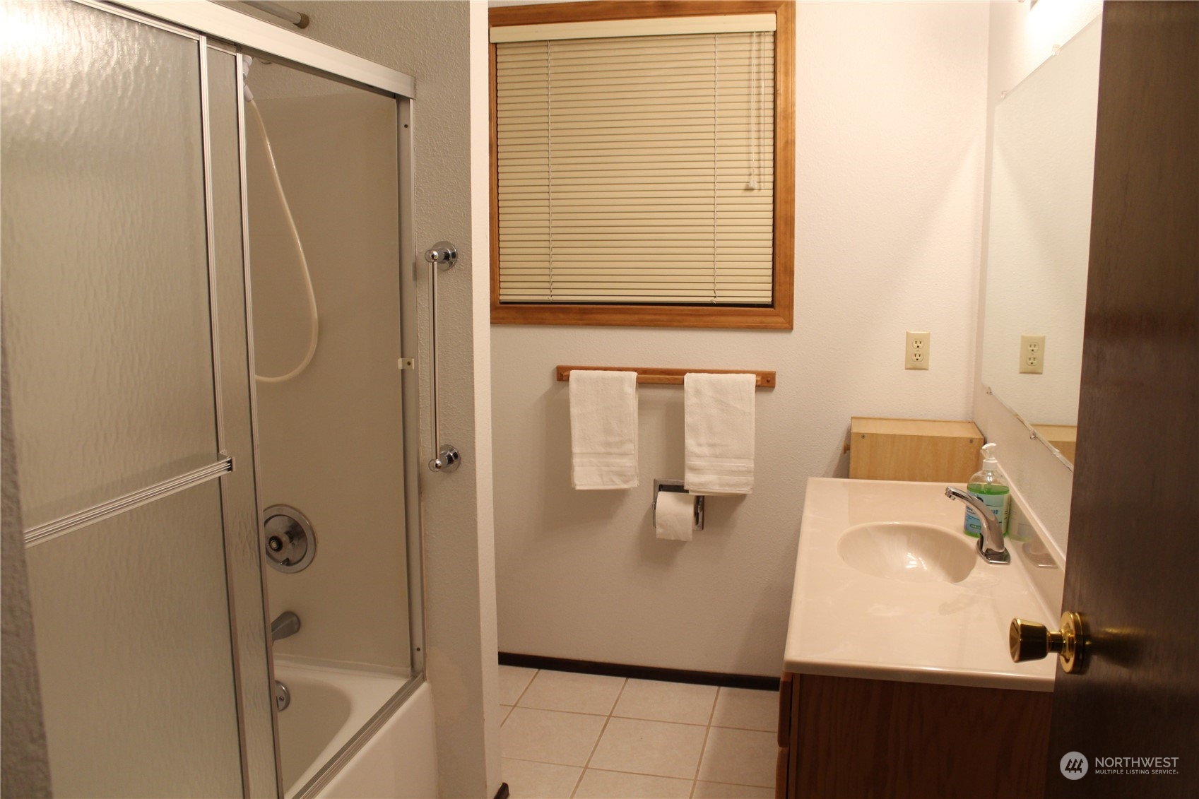 2519 Northeast 145th Street Seattle, WA 98125 - Photo 31 of 34 a bathroom with a sink a mirror and a shower