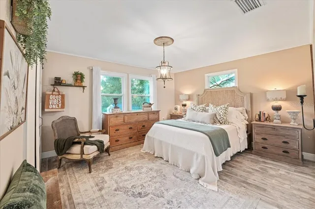 a bedroom with a large bed and a chandelier