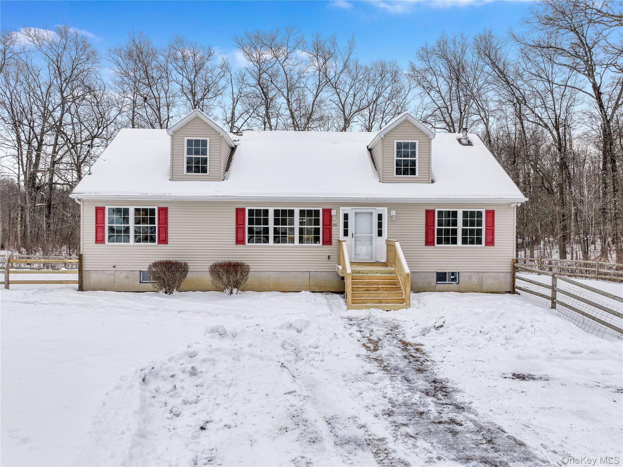 a front view of a house with a yard covered in snow