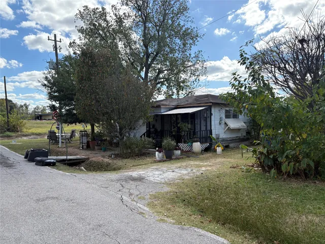 a view of a house with a yard and tree s