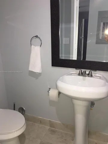 a bathroom with a sink a toilet and mirror