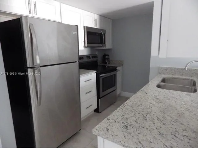 a kitchen with a refrigerator sink and microwave