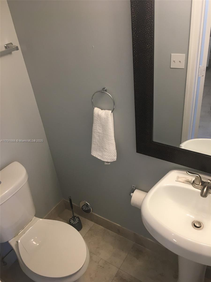 1990 Northwest 4th Court, Unit 8 Miami, FL 33136 - Photo 18 of 19 a bathroom with a sink mirror and toilet