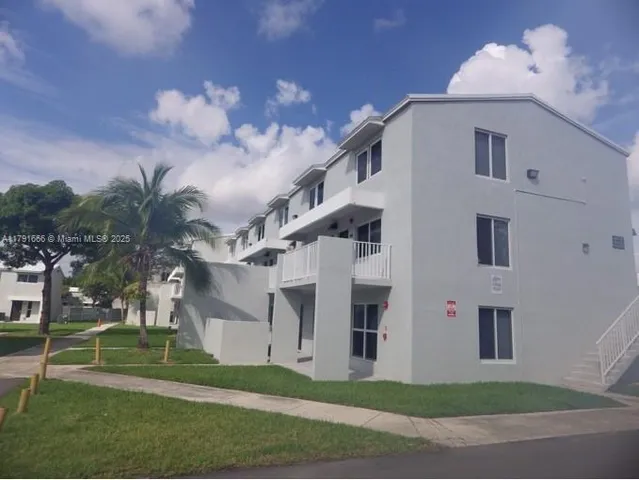 a view of a white house with a yard