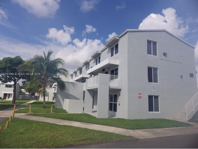 1990 Northwest 4th Court, Unit 8 Miami, FL 33136 - Photo 2 of 19 a view of a white house with a yard