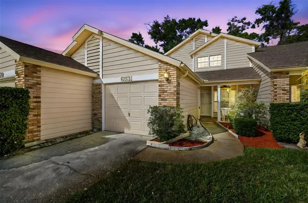 a view of a white house next to a yard