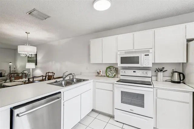 a kitchen with white cabinets sink and white appliances
