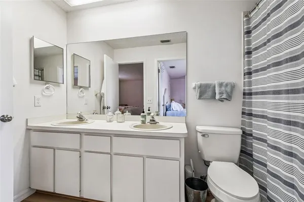 a bathroom with a toilet a sink and mirror