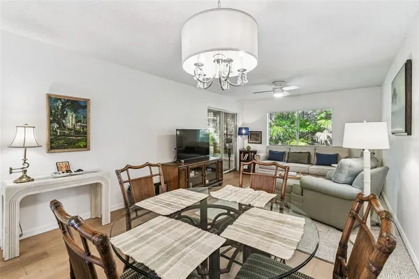 a view of a dining room with furniture a livingroom and chandelier