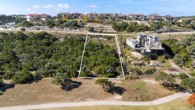 an aerial view of a house with a yard and lake view